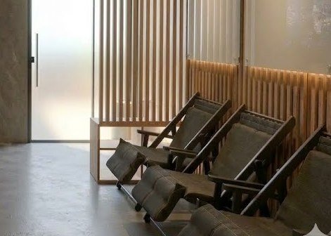 Detalhe: zona de relaxamento com cadeiras e painel ripado.